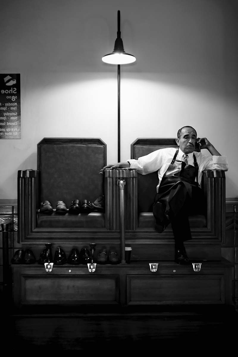 person grayscale photography of man sits on chair black-and-white
