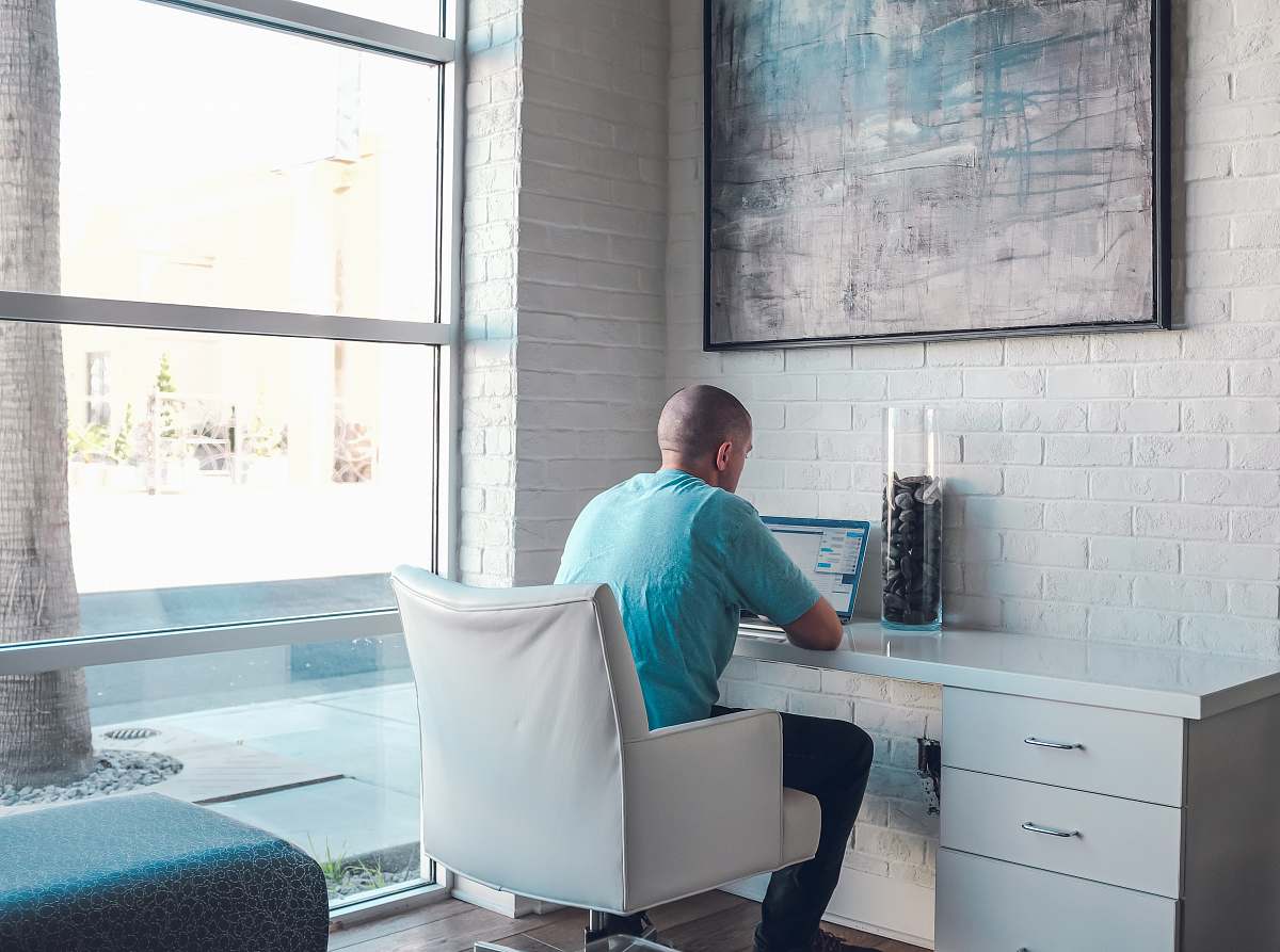 person man sitting on armchair using laptop computer people