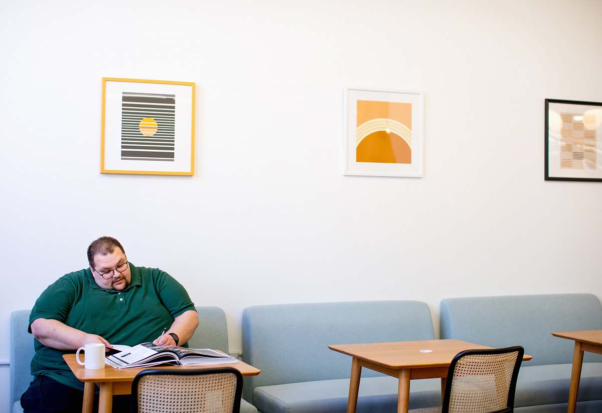 person man sitting on sofa wrting on paper chair