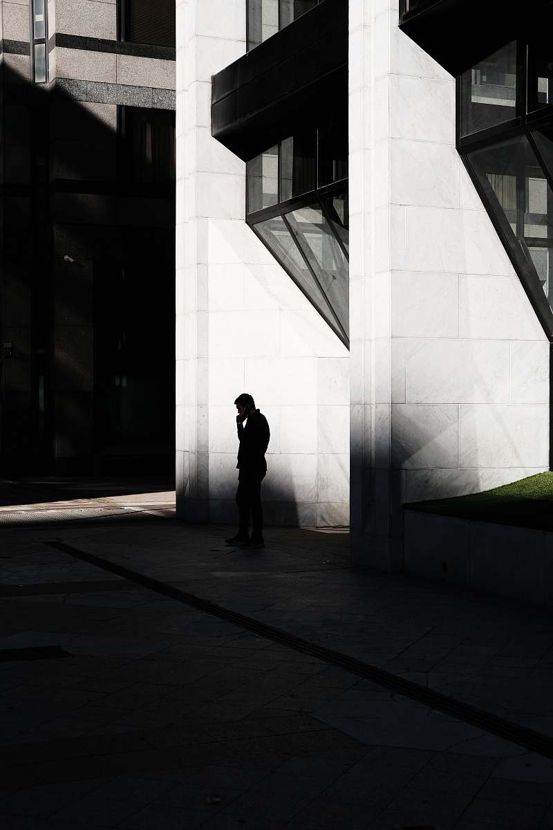 person man standing near buildings in grayscale photography silhouette
