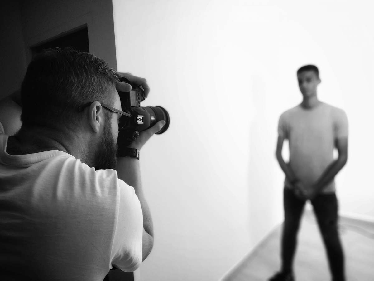 person man taking photo of another man black-and-white