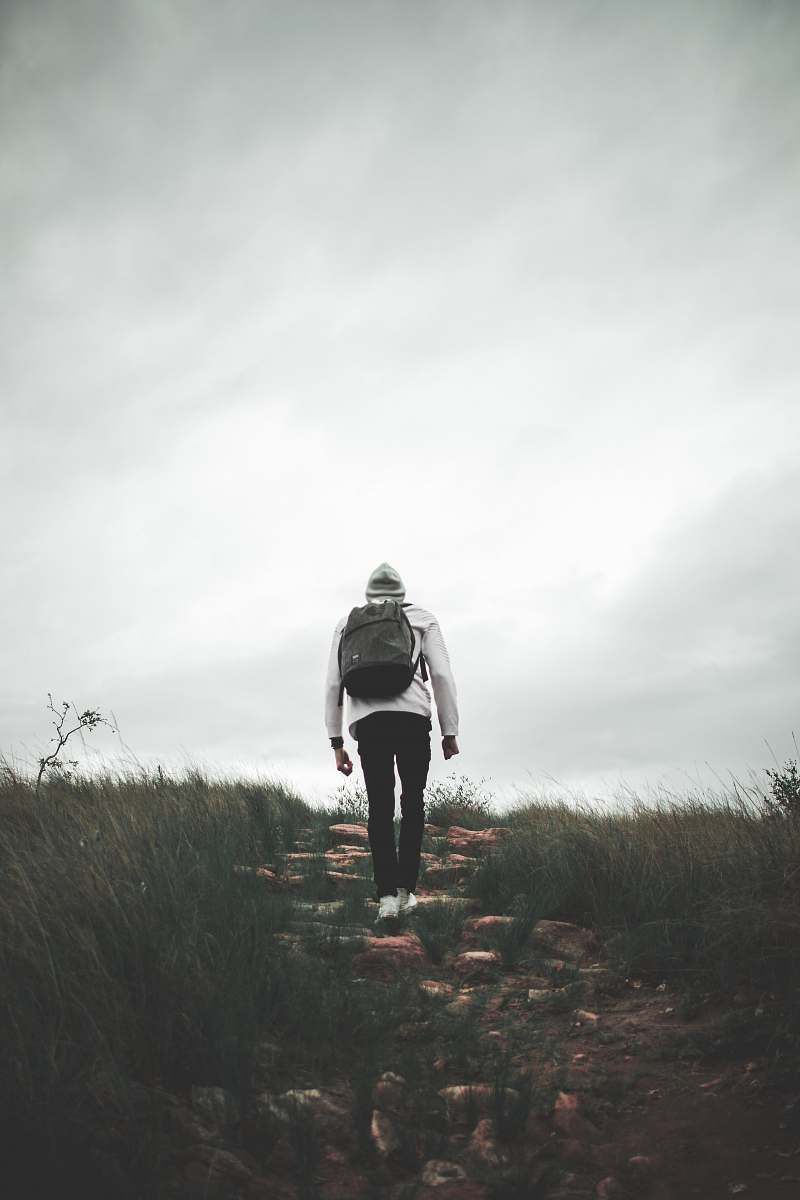 person man wears black backpack walking