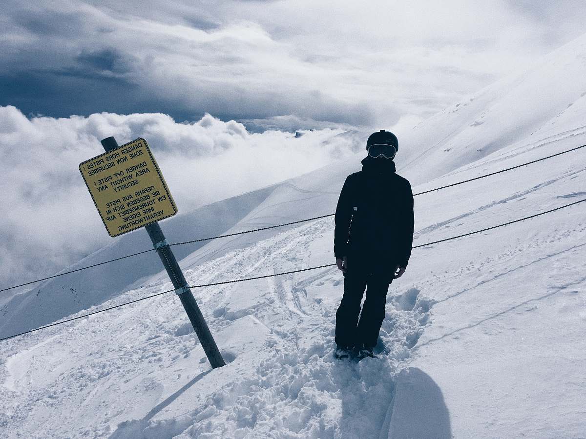 nature person in snowsuit standing beside sign outdoors