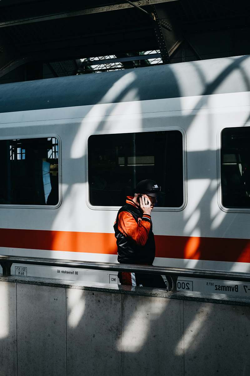 person person walking near white and orange train train