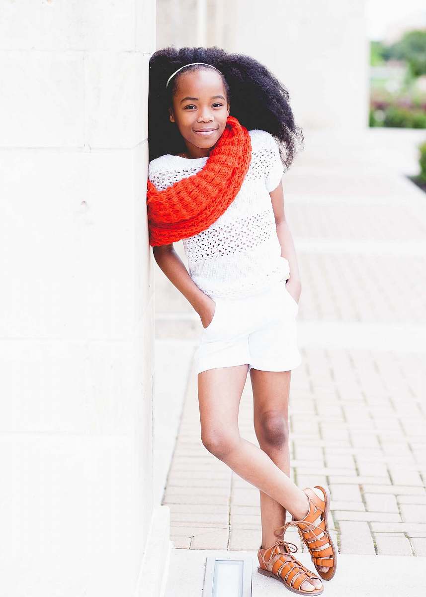 person smiling girl in white shirt and shorts wearing red scarf during daytime people