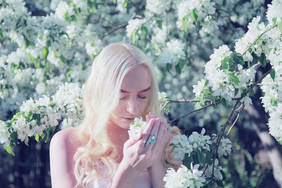 person woman smelling flower during daytime people