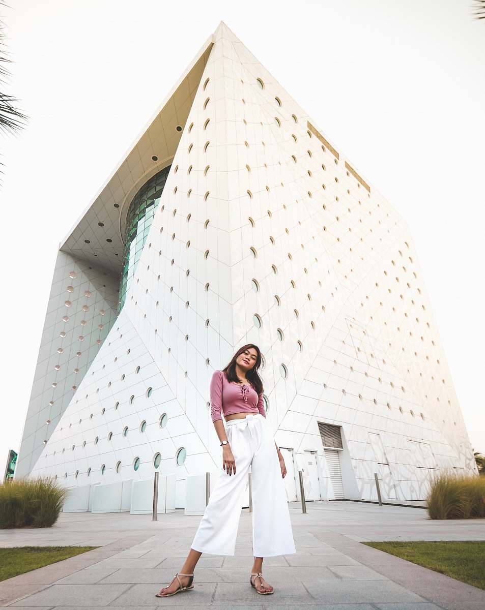 apparel woman standing near white concrete building clothing