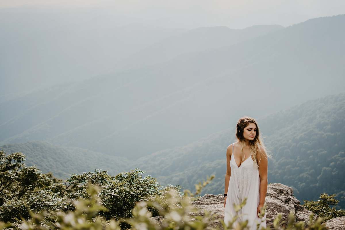 people woman standing on brown rocky terrain at high altitude person