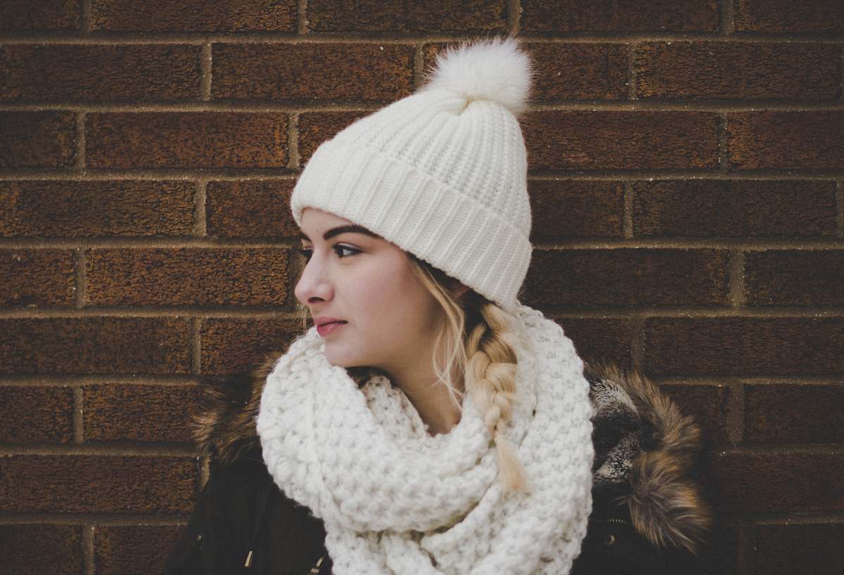 person woman wearing white bobble beanie hat