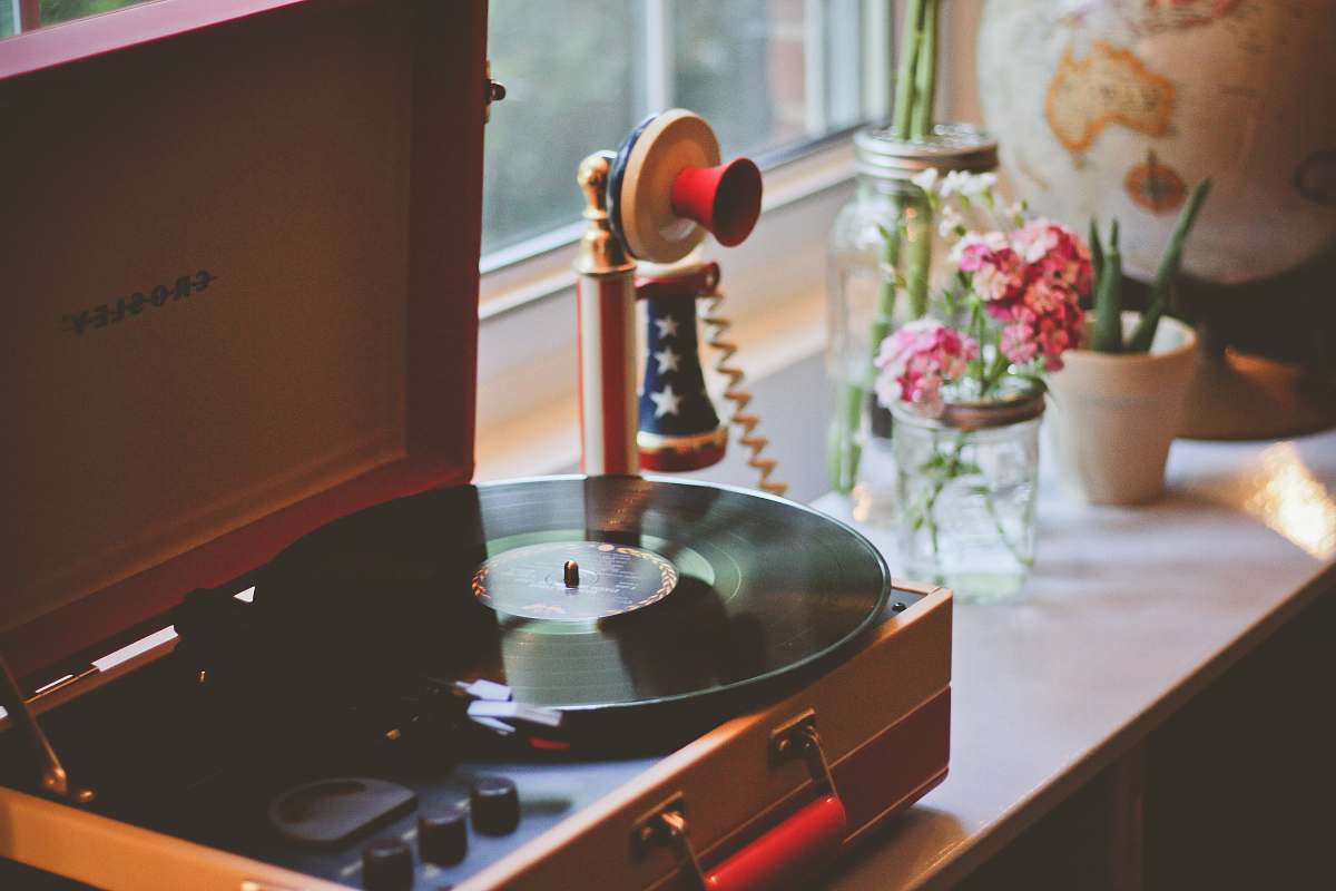 plant brown Crosley turntable beside candlestick telephone flowers