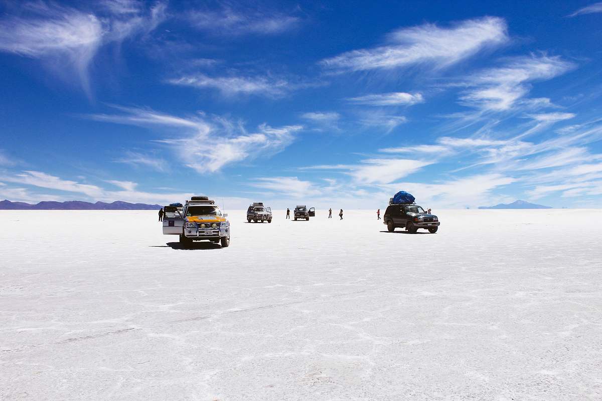 desert sports utility vehicles on desert under cloudy blue sky during daytime uyuni