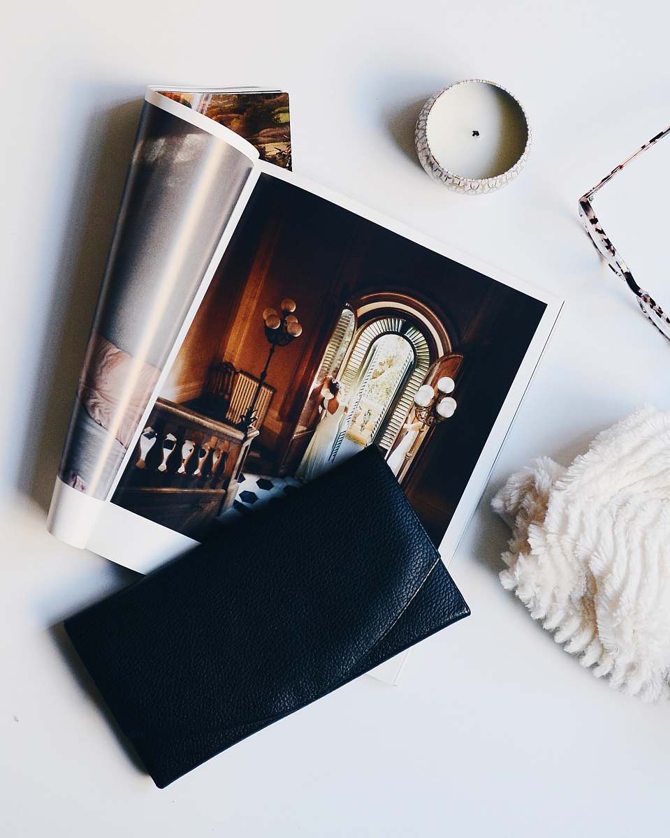 candle black leather purse on magazine page from above