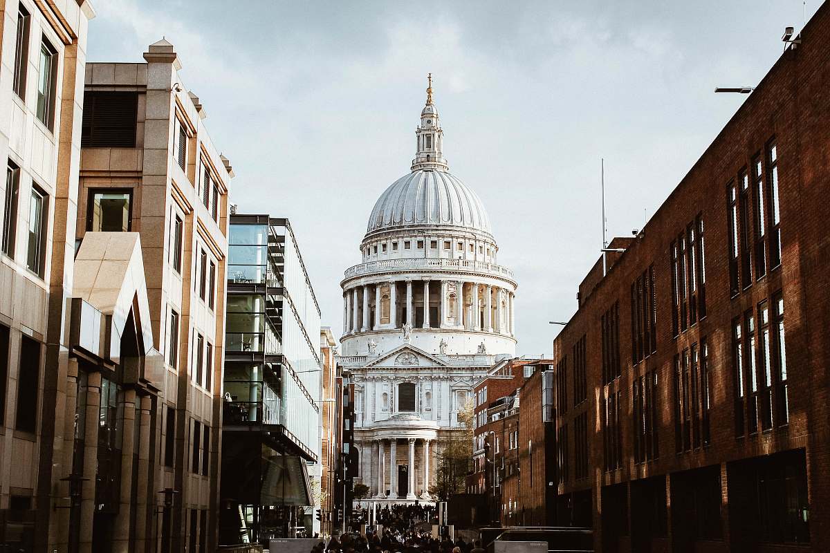 building white building with dome under white clouds during daytime street