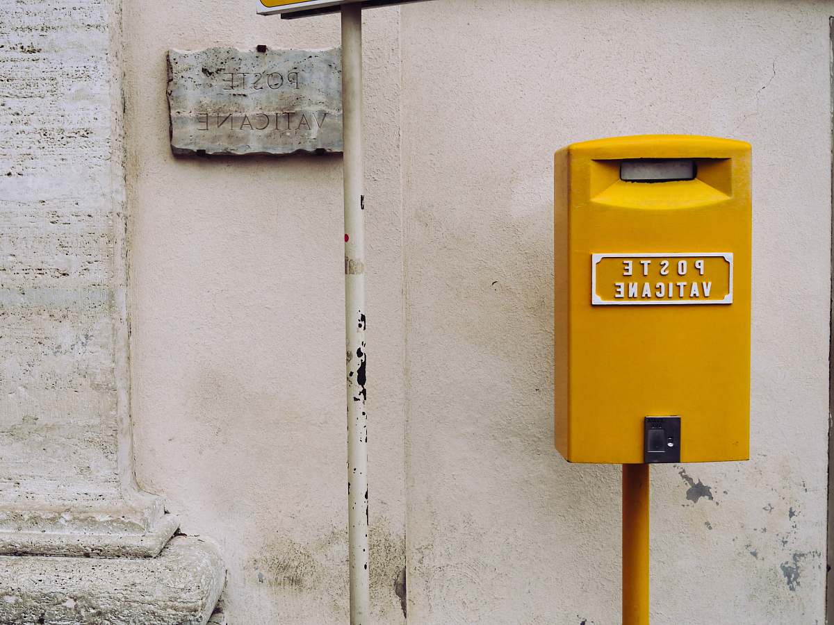 postbox yellow poste vaticane meter beside white wall wall