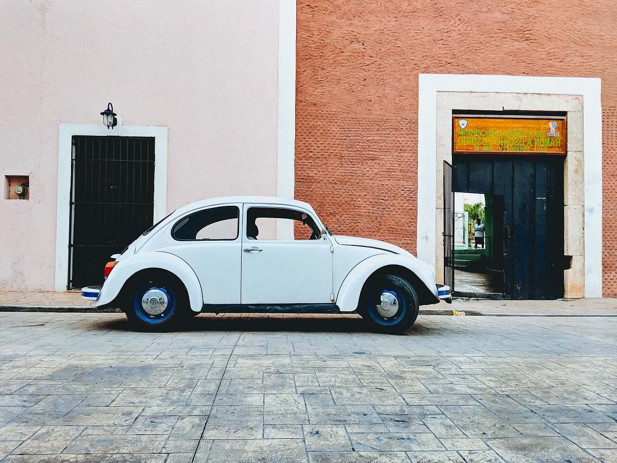 vehicle white Volkswagen beetle parked near building during daytime car