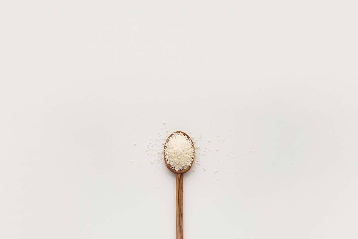 food white powder on brown wooden spoon spoon