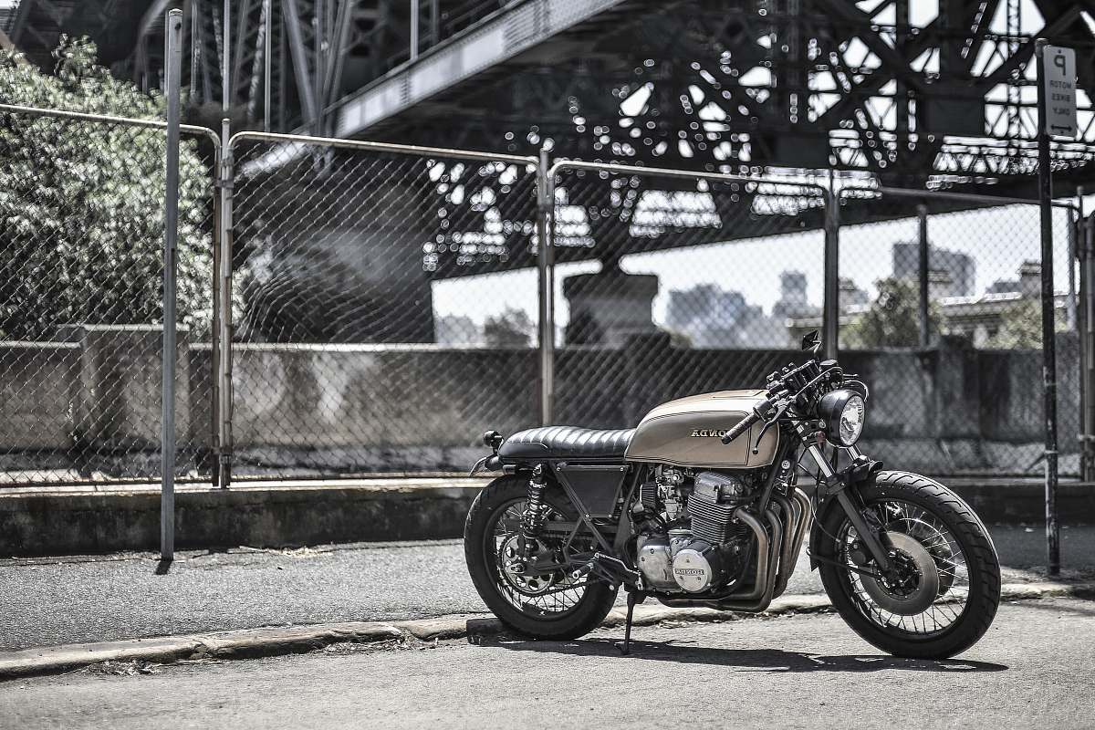 vehicle brown standard motorcycle near wire fence during daytime transportation