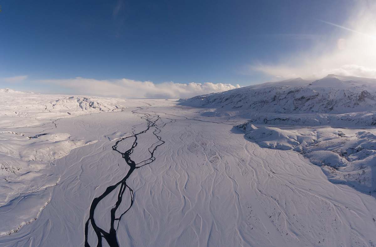 iceland landscape photo of snowy mountains under cloudy sky during daytime ice