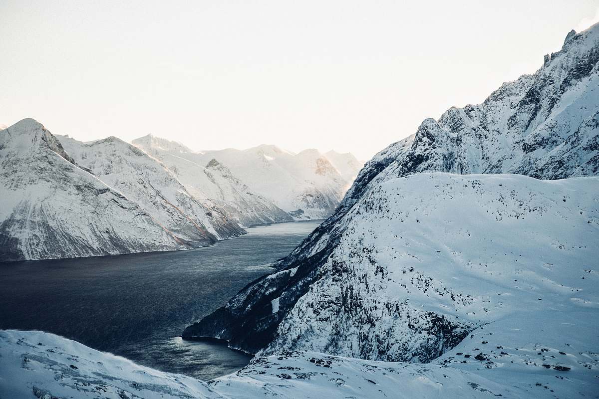snow landscape photography of snow-coated mountains near body of water during daytime nature