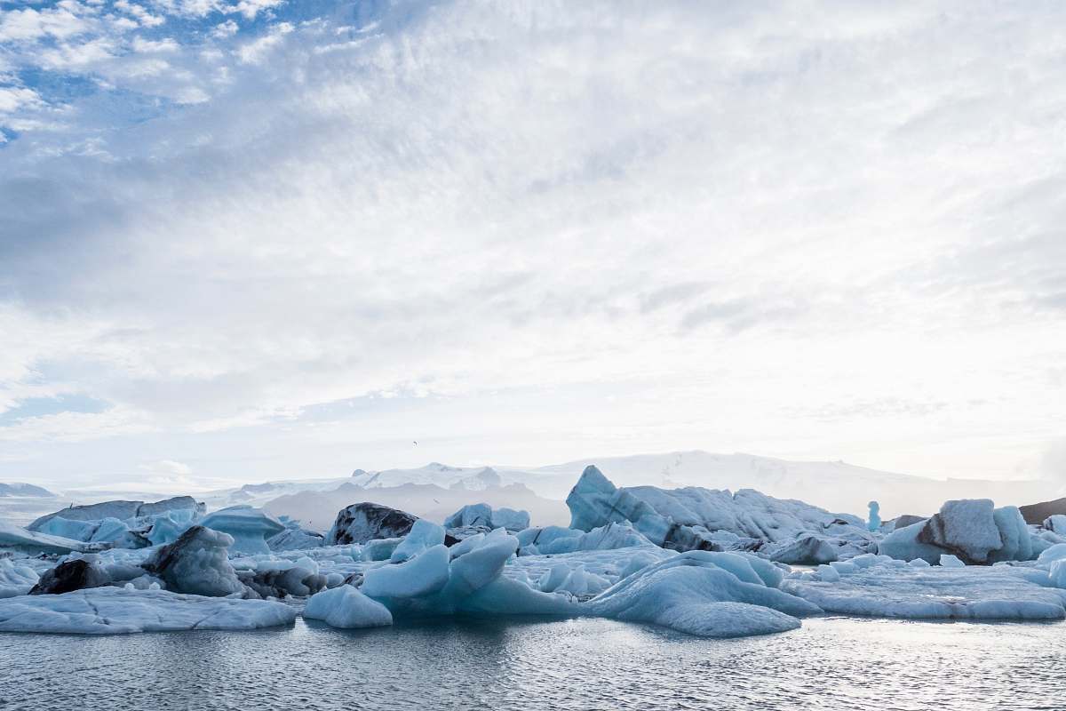 glacier rock formation beside body of water ice