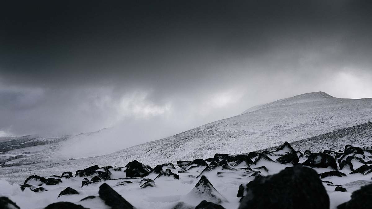grey snow covered mountain under gray clouds at daytime snow