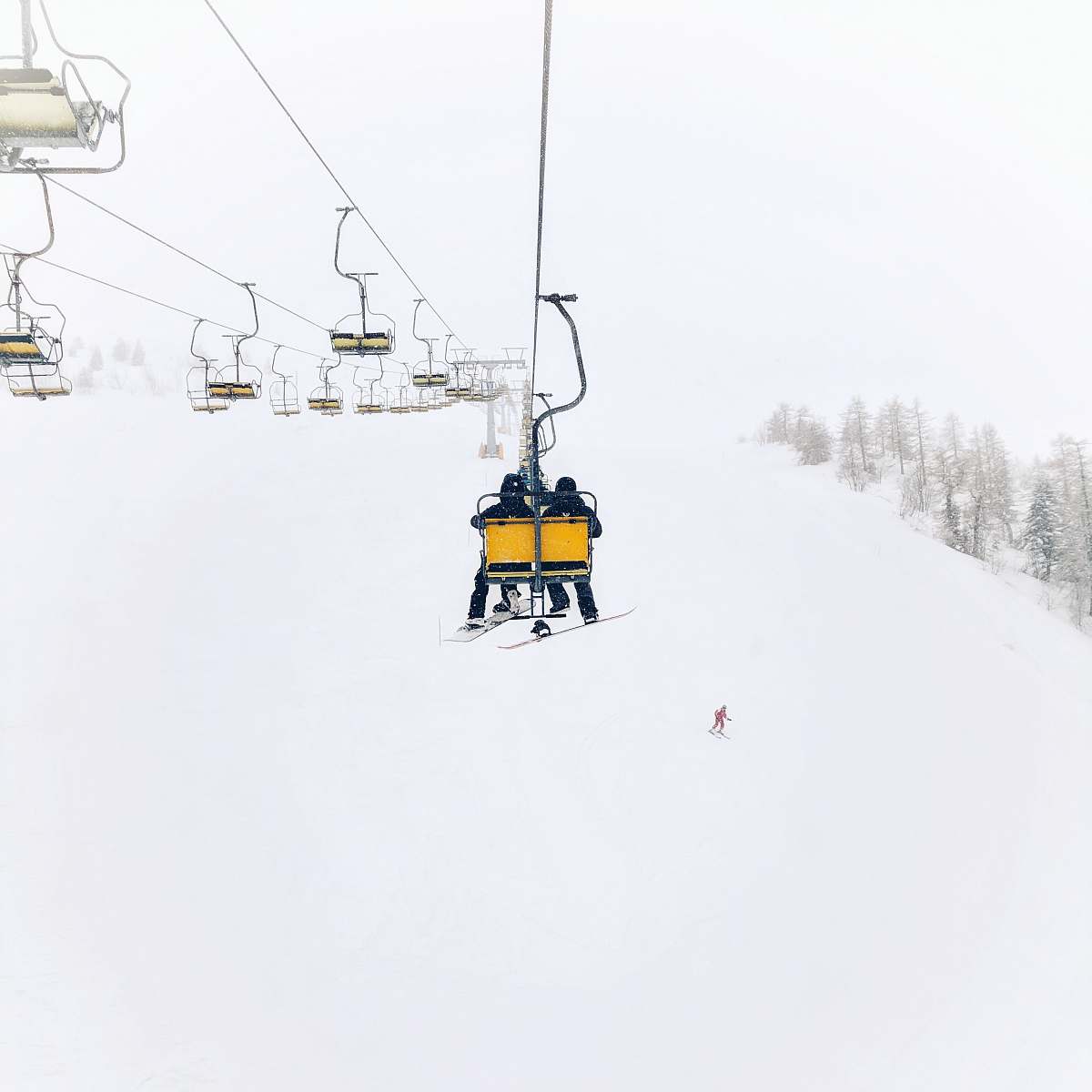 krvavec two person riding on cable transportation through top of the hill during winter cerklje na gorenjskem