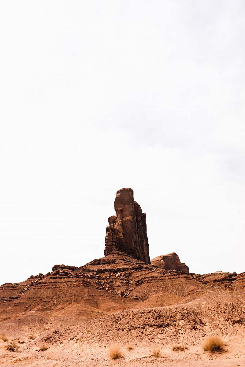 outdoors brown rock formation under white sky monument valley