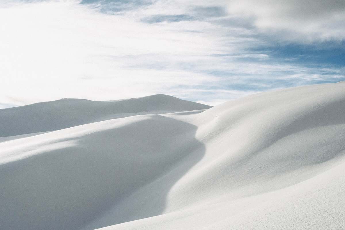 white desert under white clouds during daytime mountain