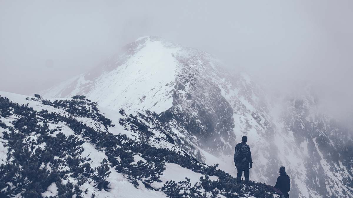 grey people standing on top of mountain mountain