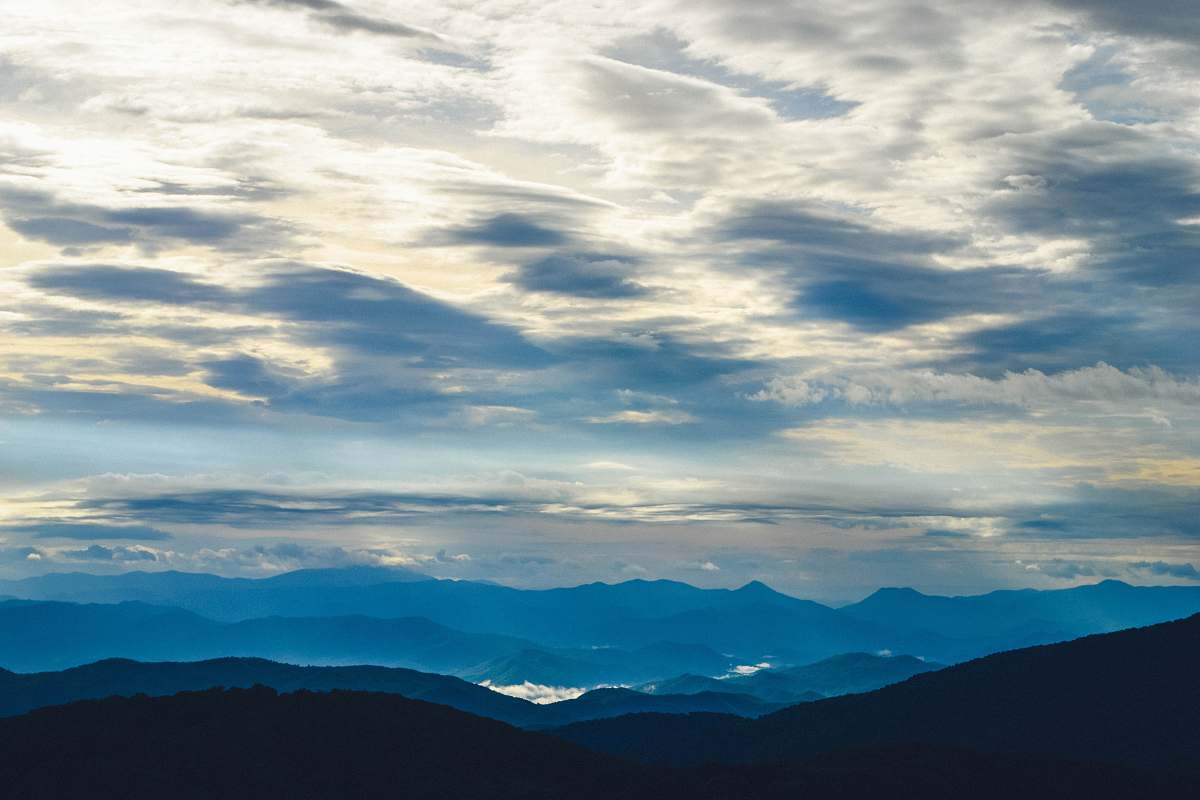 cloud silhouette of mountains under sea clouds sky