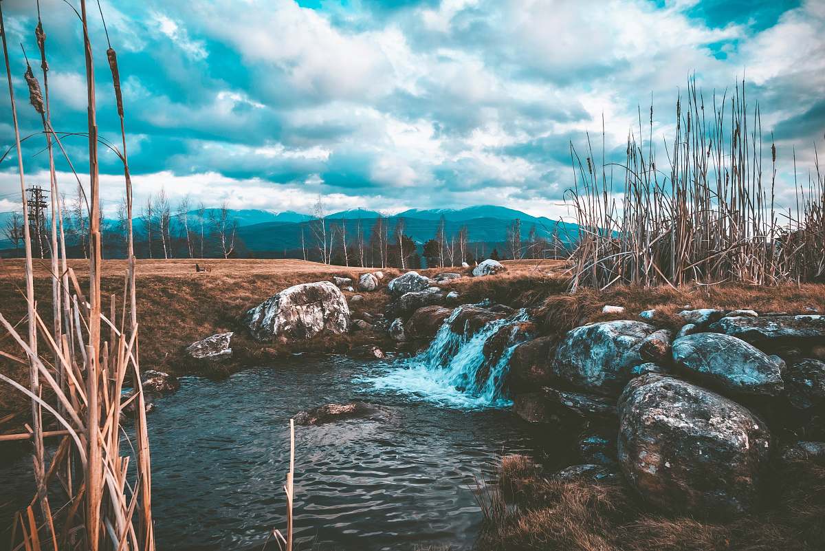 water stream of water near brown soil and stone stream