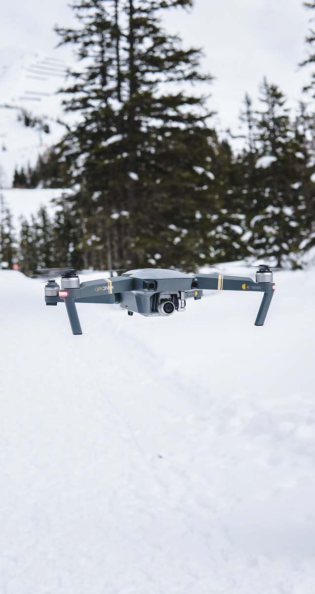 flight gray flying quadcopter near trees with snow winter