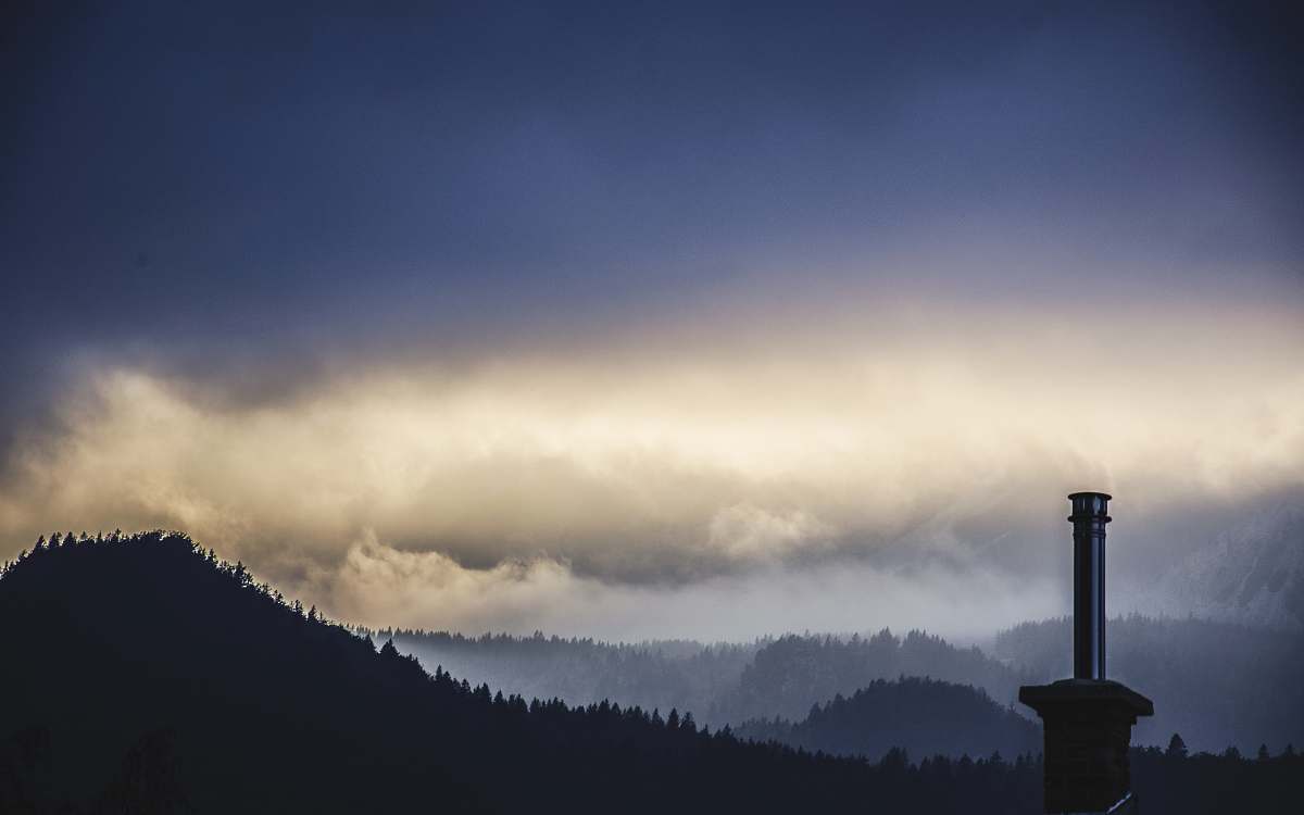 cloudy lighthouse on mountain trees