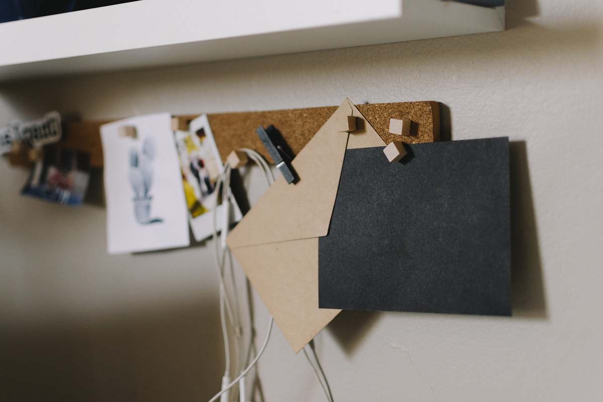 white brown cork board with papers shelf