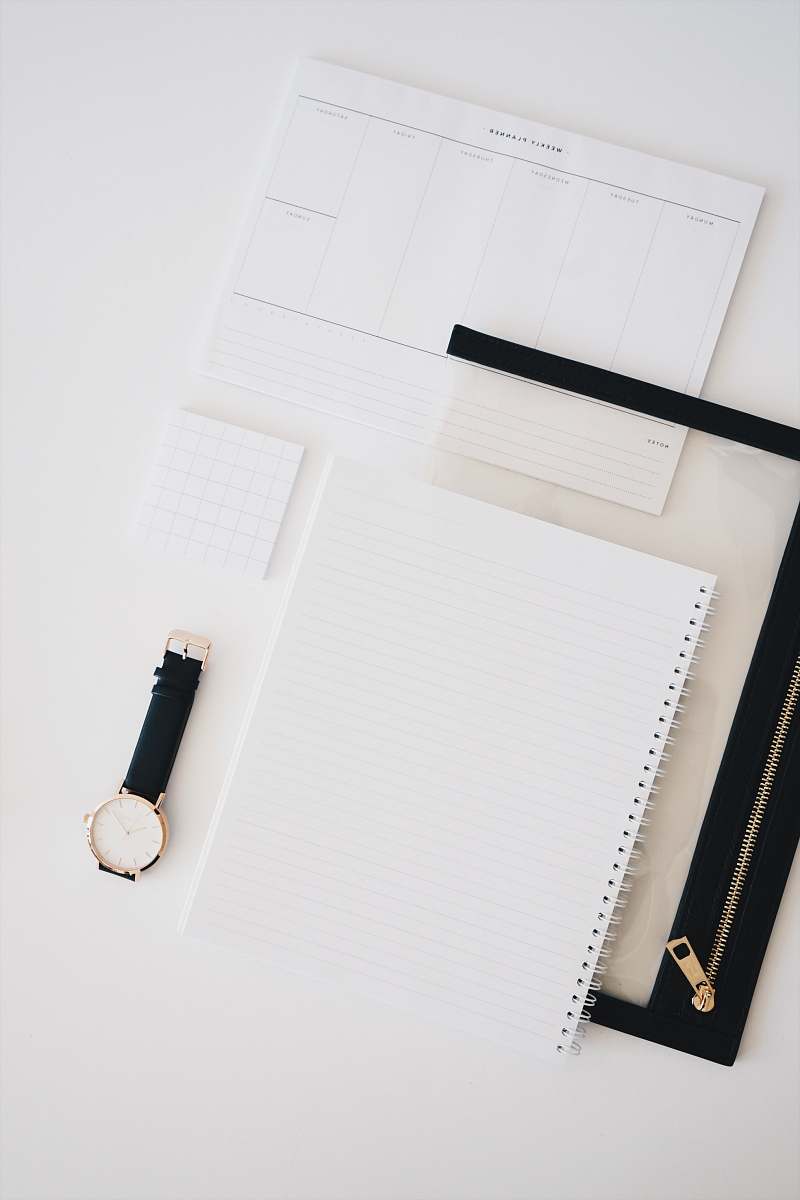 wristwatch gray lined paper on table white