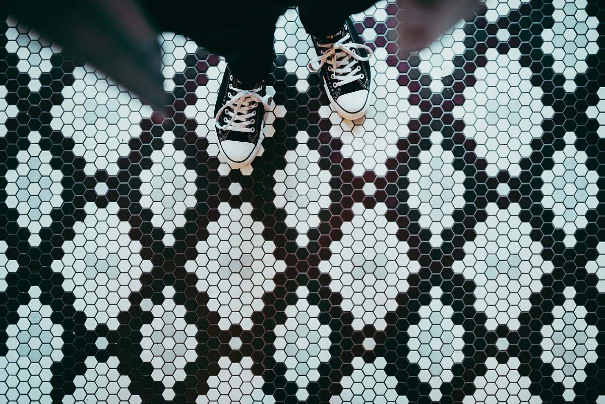 shoe person standing wearing black sneakers tiles