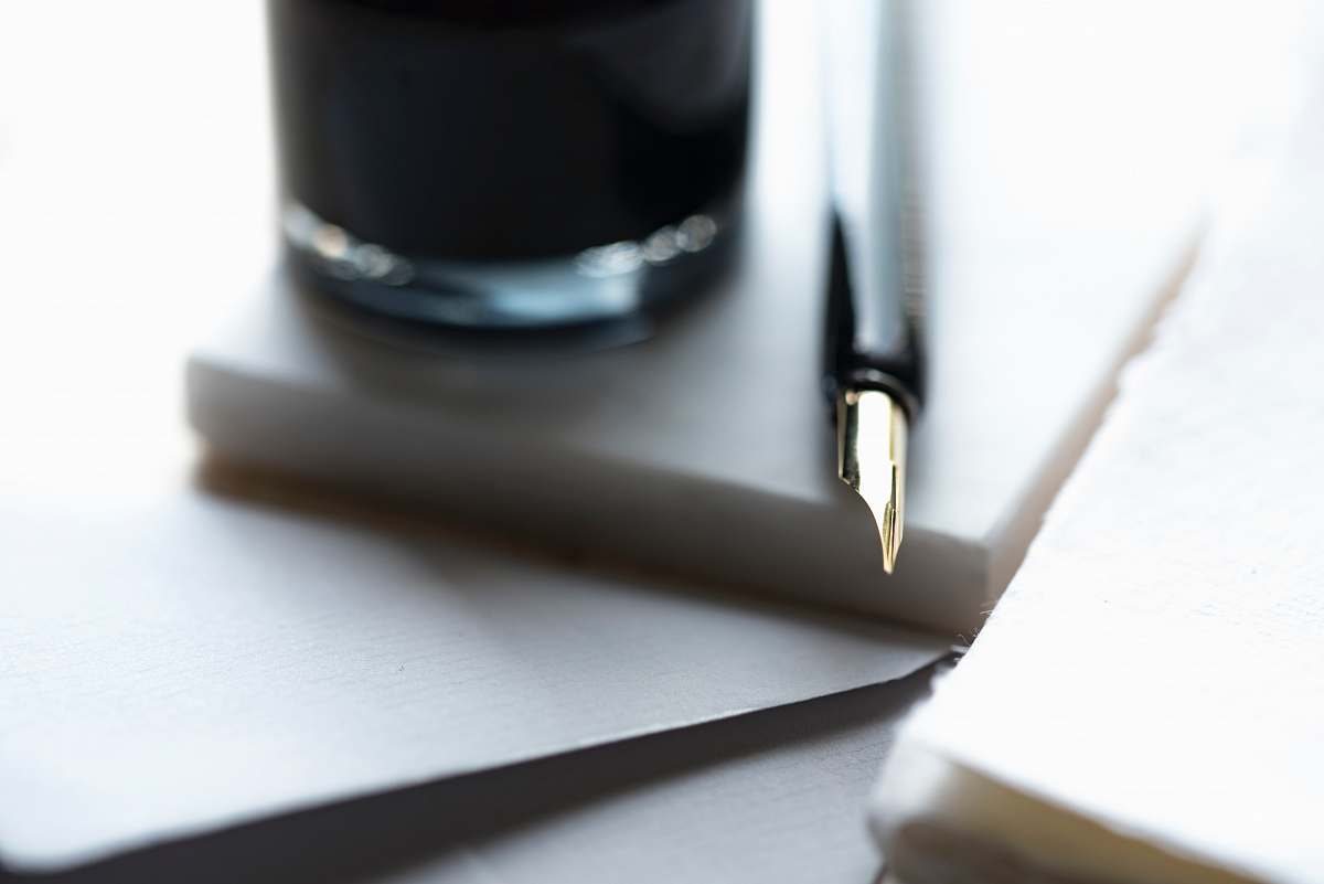 nib fountain pen beside the glass calligraphy