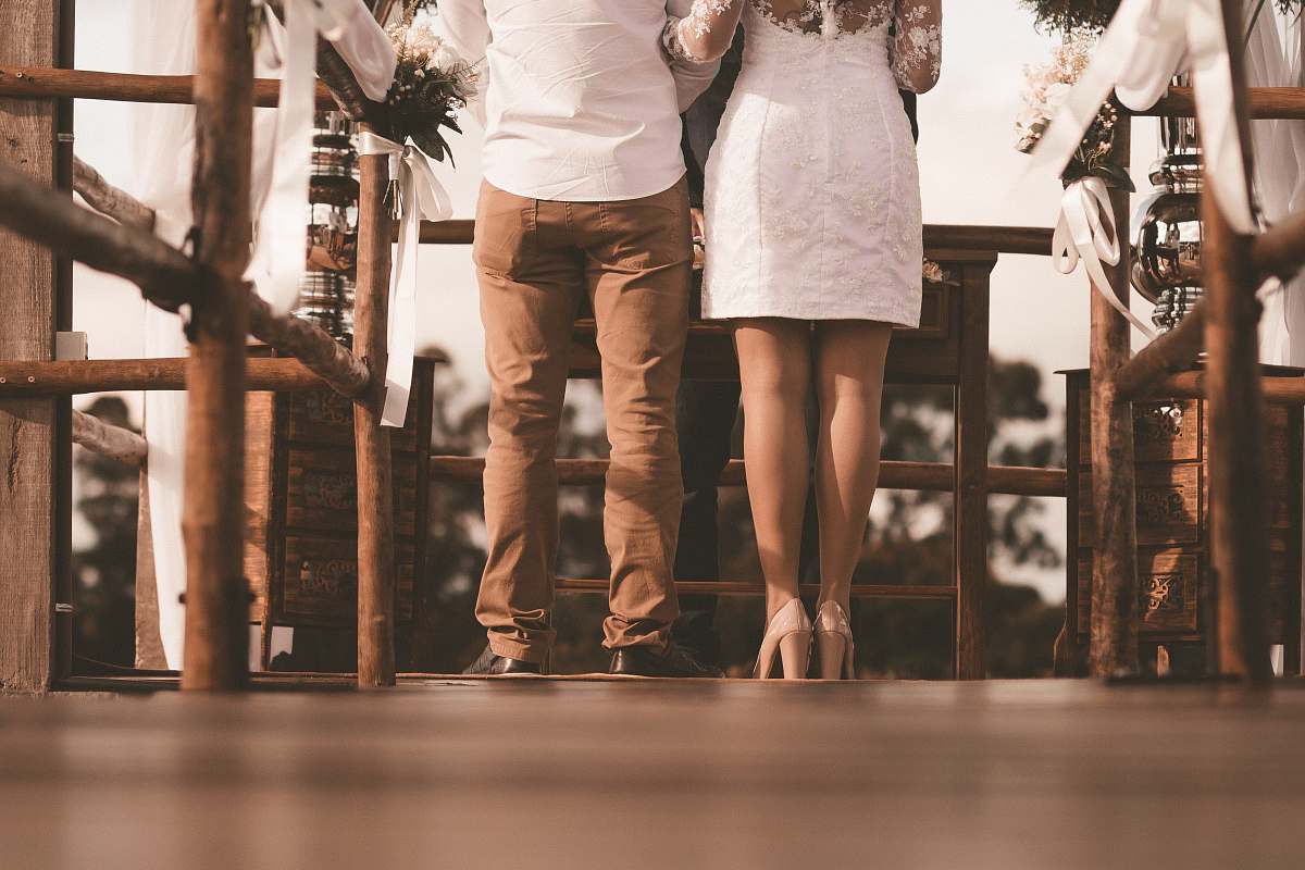 wedding couple standing on front of brown table at daytime human