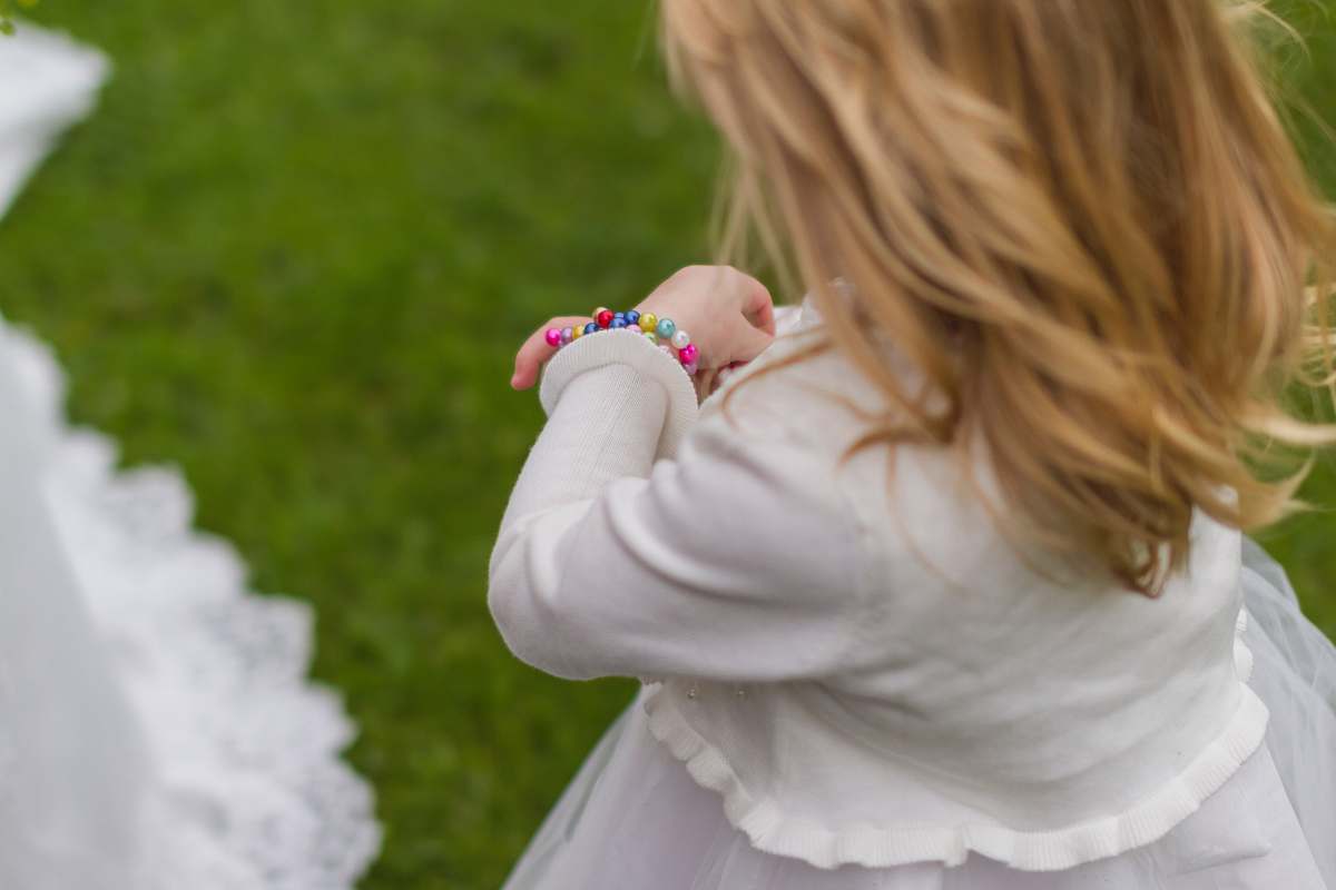 human girl wearing white dress holding her bracelet people