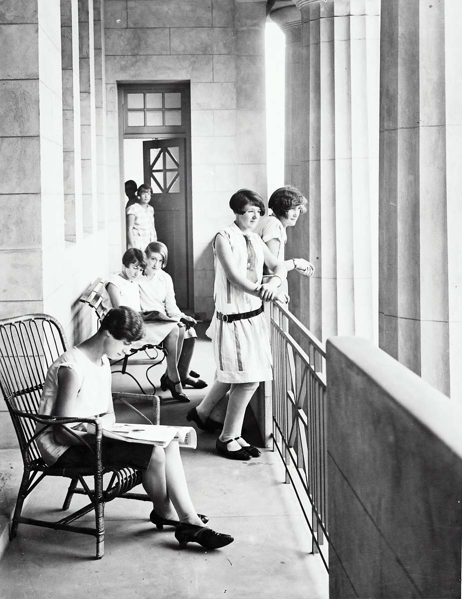 human group of woman sitting and standing beside railing black-and-white