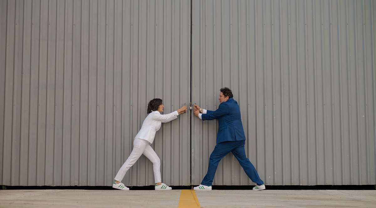 human man and woman standing beside gray wall people