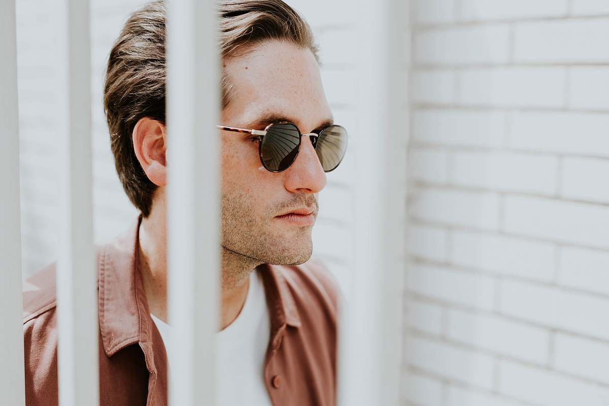 people man behind white bars glasses