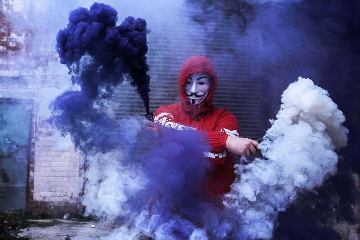 eruption man wearing red hoodie standing near gray wall during daytime photo nature