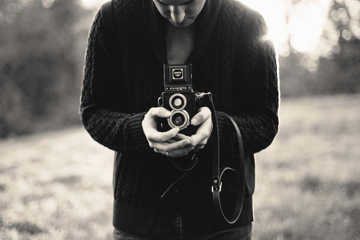 camera person holding double-lens camera human