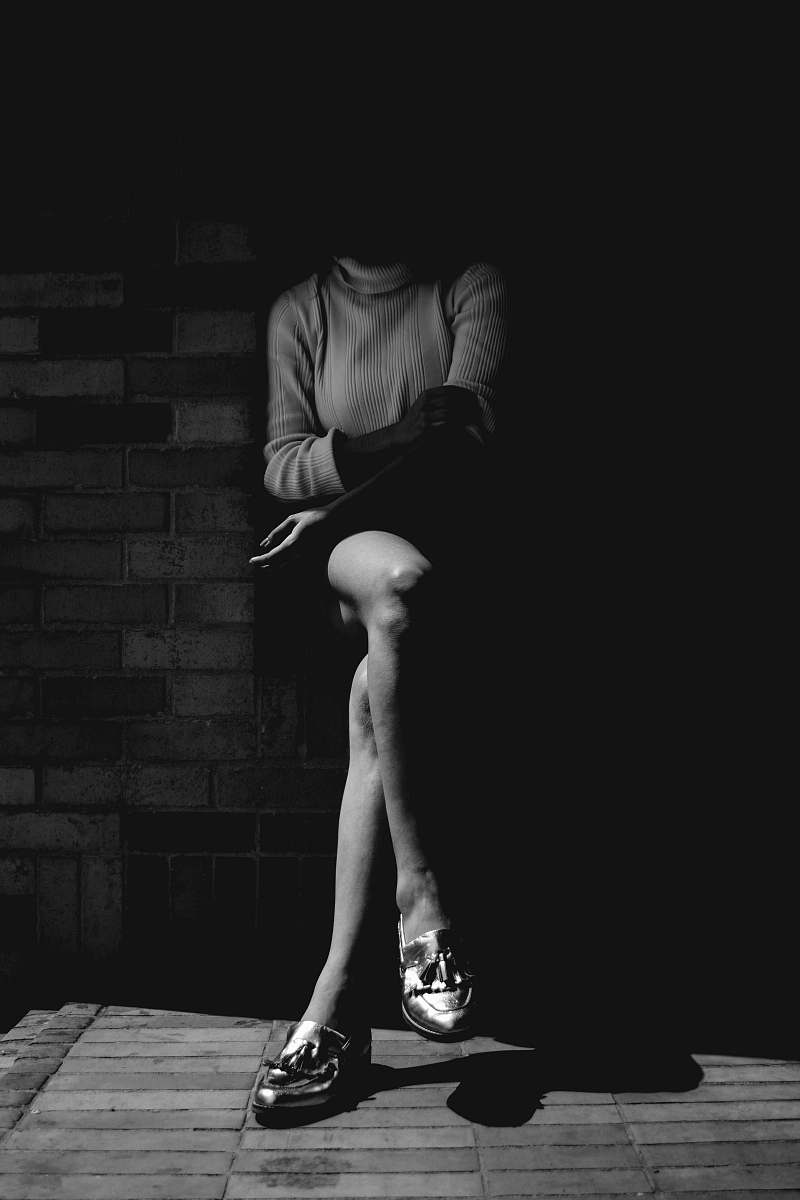 black-and-white person sitting near wall people