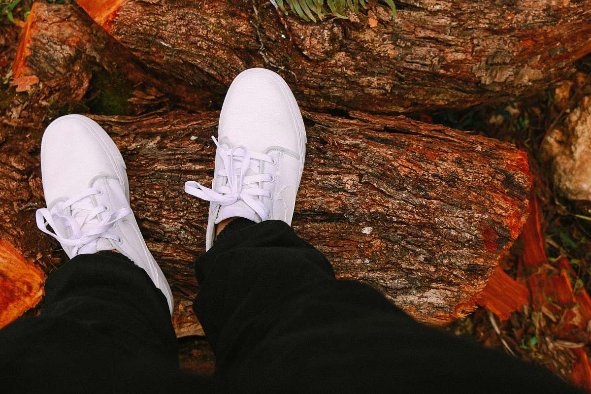 feet person standing on wood slabs shoes