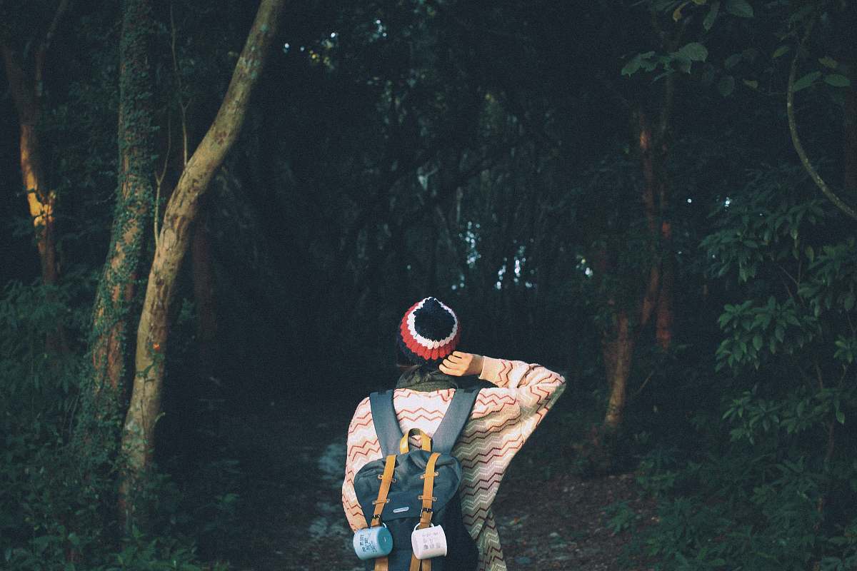 human photo of woman standing front of trees people