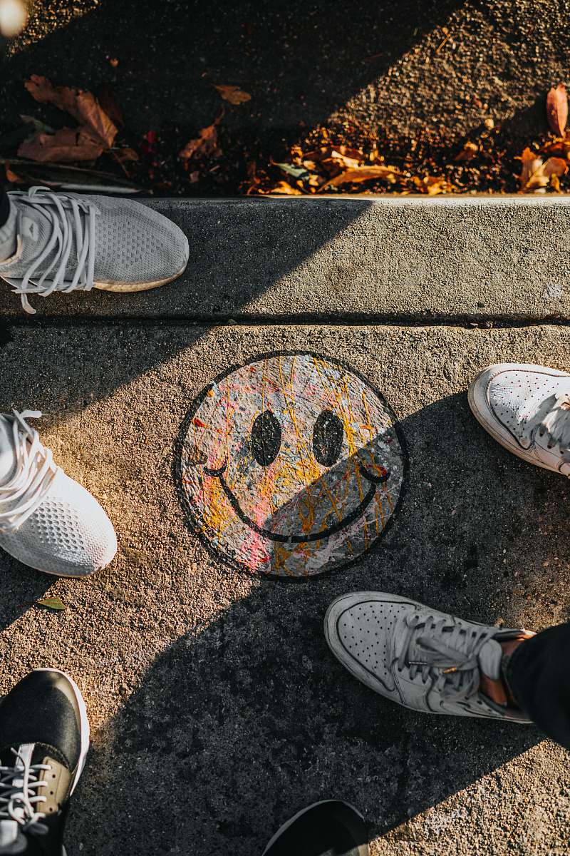 human smiley paint on gray ground in front of people people