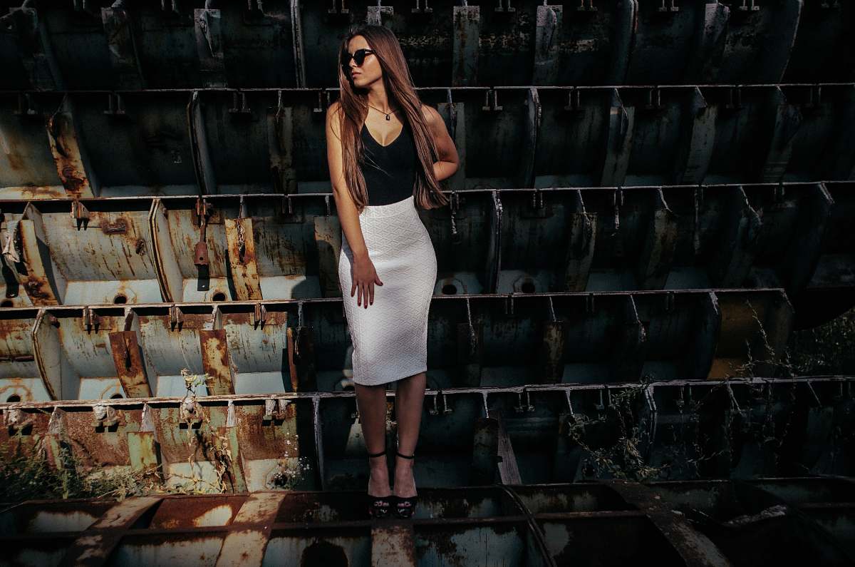 rust woman in black and white sleeveless dress on gray and brown steel frames woman