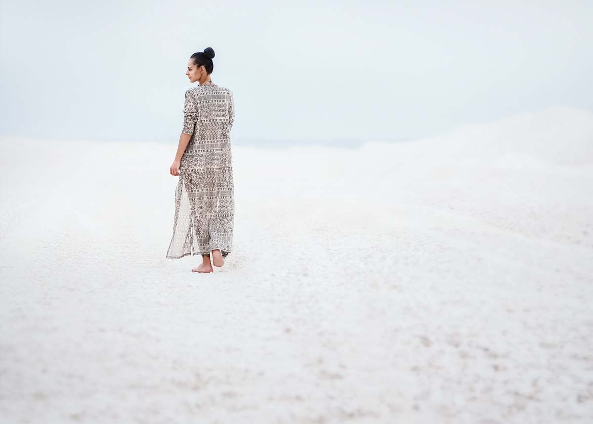 people woman in gray dress walking on sand human
